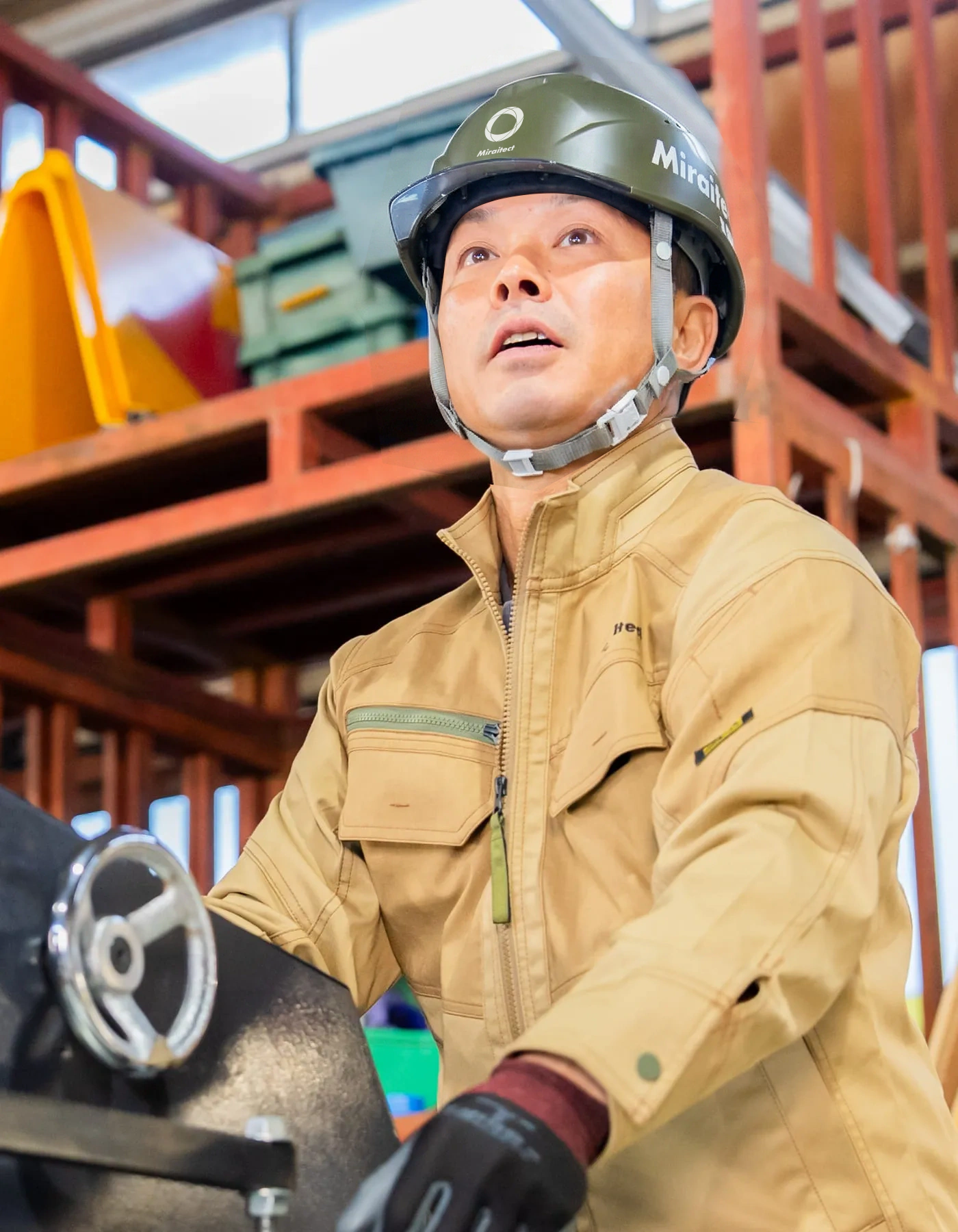 上方を確認しながら機械操作を行う職人の姿