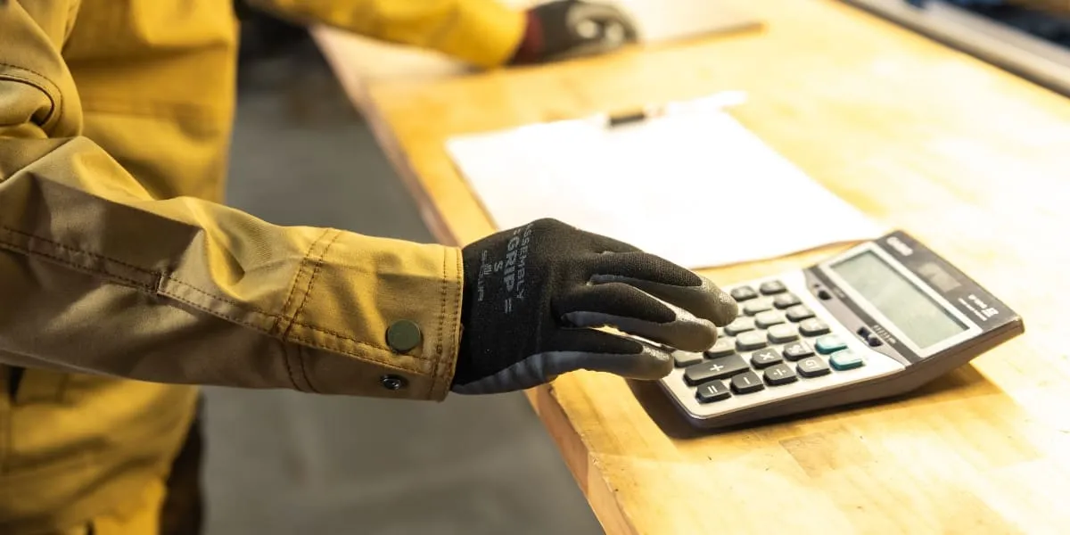 手袋を着用して電卓を操作する職人の姿